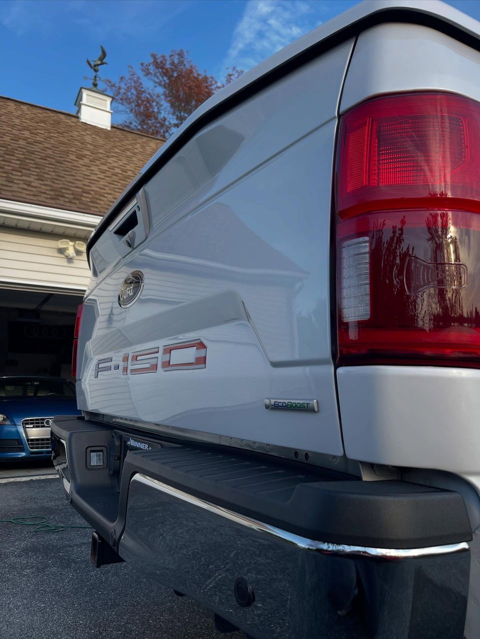High-gloss Ford F-150 tailgate and taillight reflecting the sky after exterior cleaning