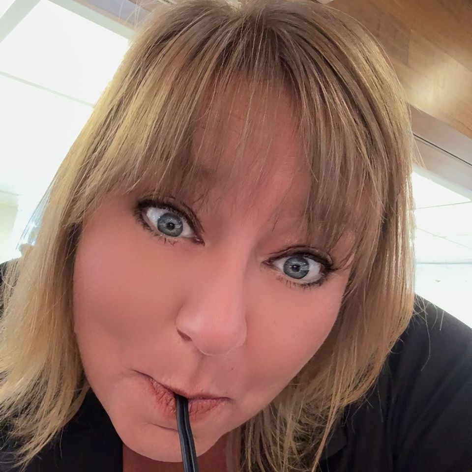 Portrait of Tracy smiling while enjoying a drink, showcasing her friendly and approachable personality.
