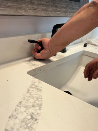Kenny making repairs on a bathroom faucet. plumber