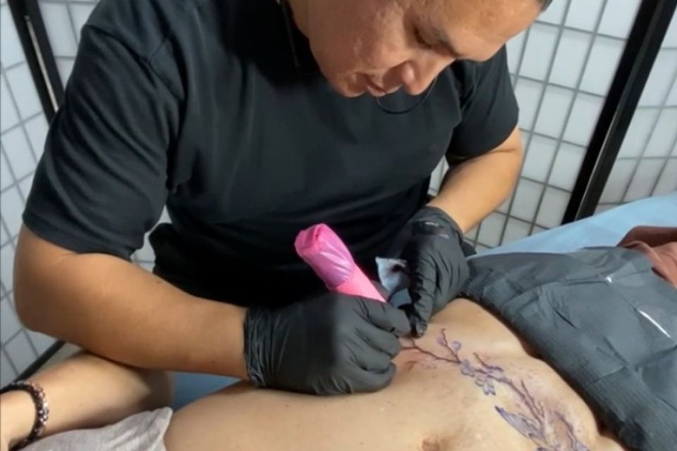 Image of Adrian Anderson creating a tummy tuck tattoo