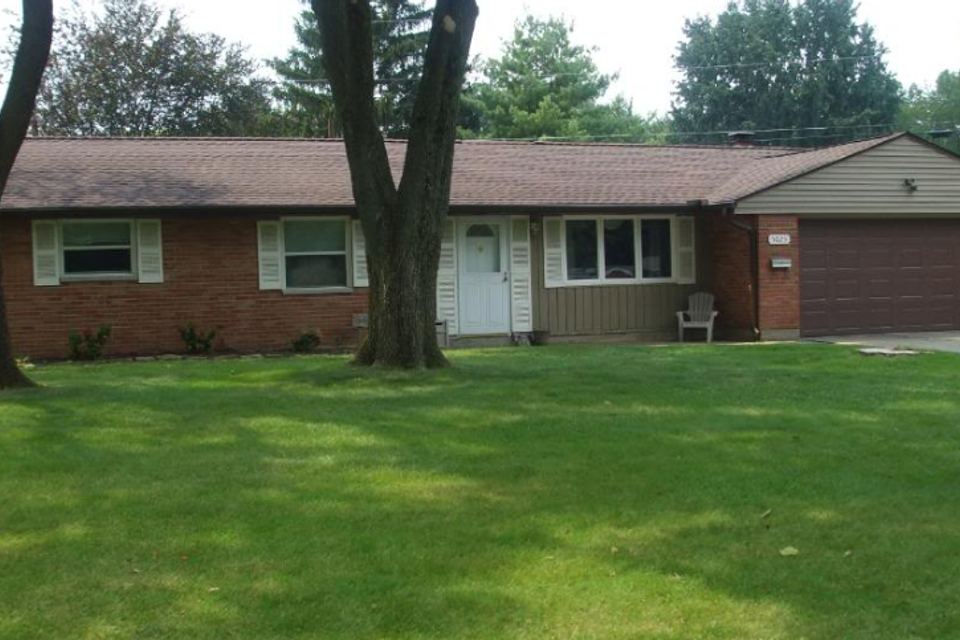 Brick home featuring a durable asphalt shingle roof installed by E & D Roofing, Inc.