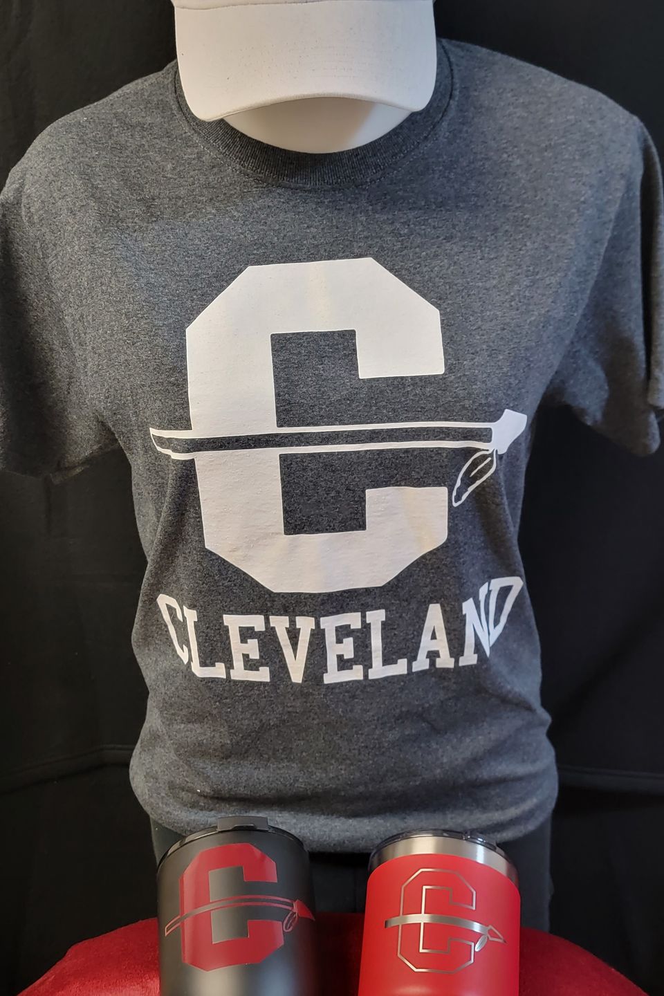 Example of Direct to Film (DTF) transfer - alternate Cleveland logo on a gray t-shirt, embroidered logo white cap, and tumblers. 