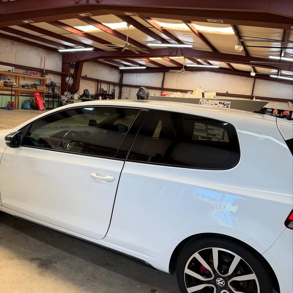 White Volkswagen GTI with freshly applied window tint inside a Moyock North Carolina tint shop