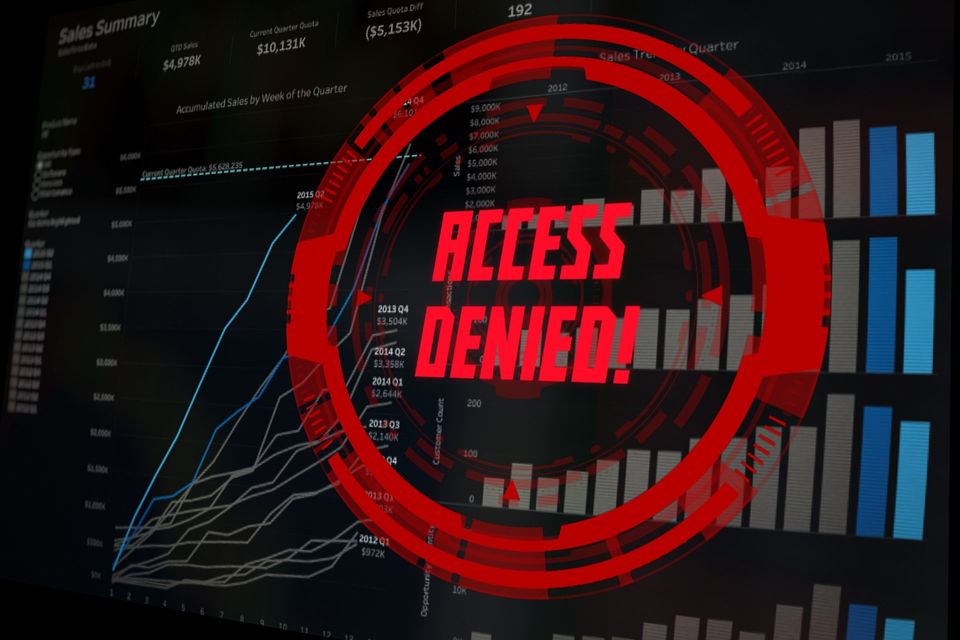 A digital screen displaying various charts and graphs is overlaid with a prominent red warning symbol and the text 'ACCESS DENIED!