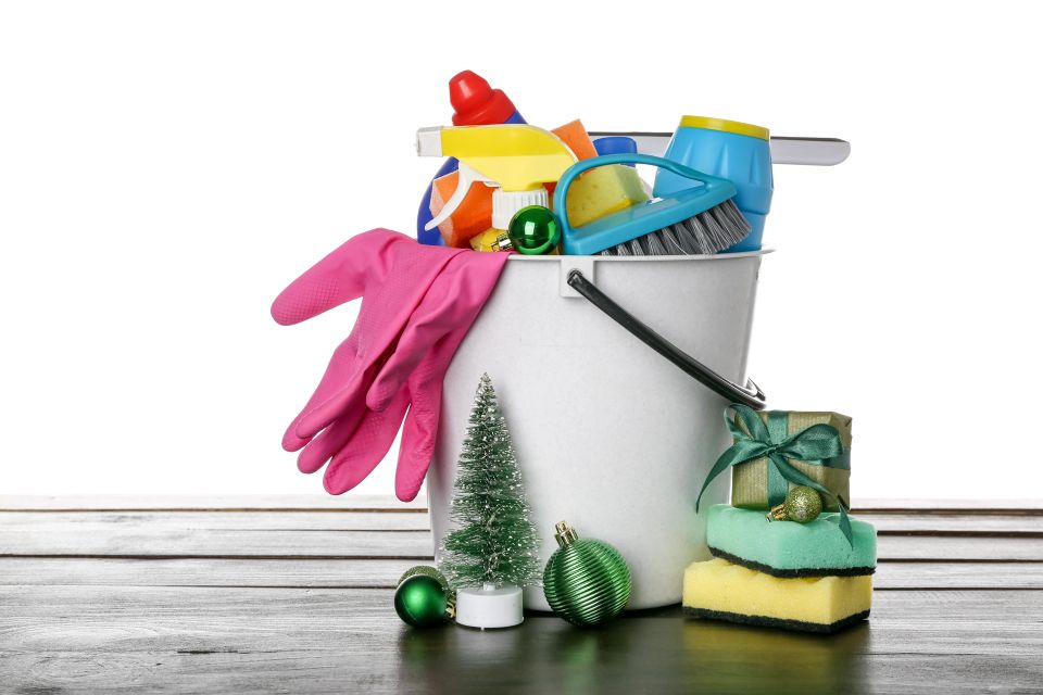 A bucket with cleaning supplies and Christmas ornaments around it