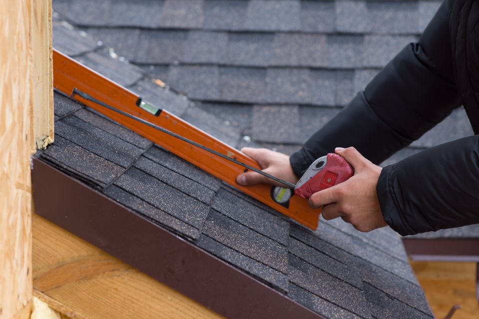 Roofer holding tape measure and level