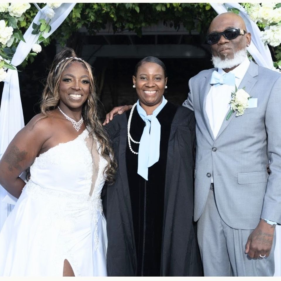Dee   taking a picture  with the bride and groom  at a wedding  nyc