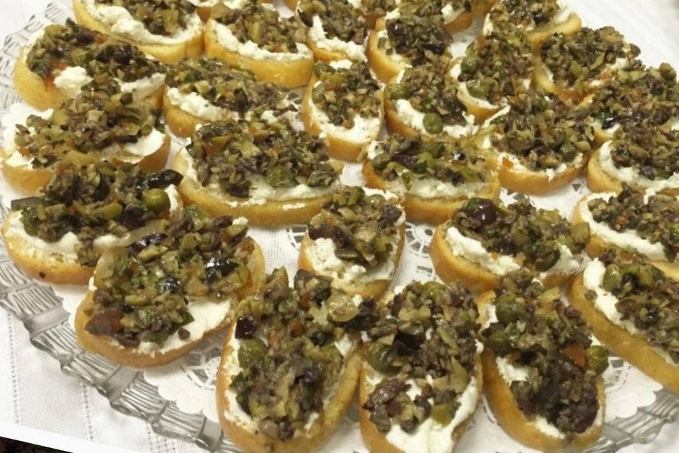 Goat cheese crostini topped with new orleans style olive salad