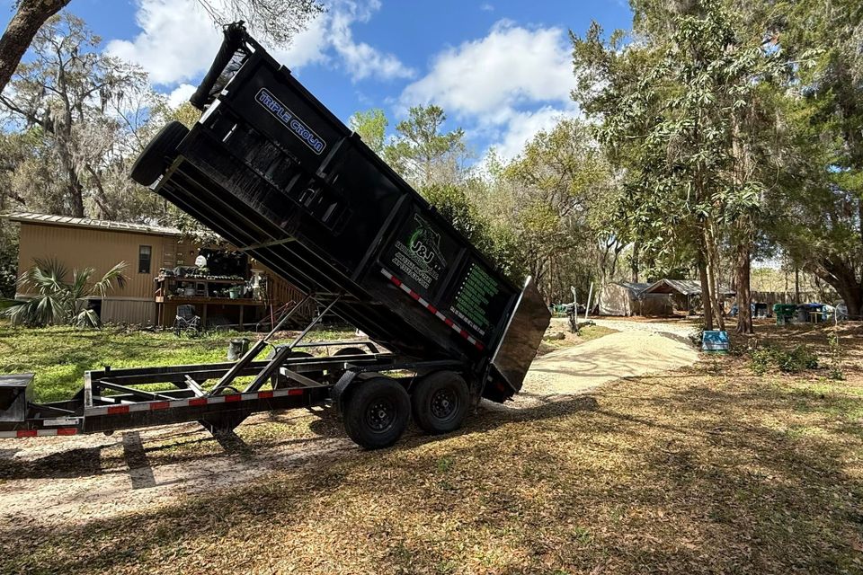 JNJ Hauling Solutions dumpster in the downward emptying position