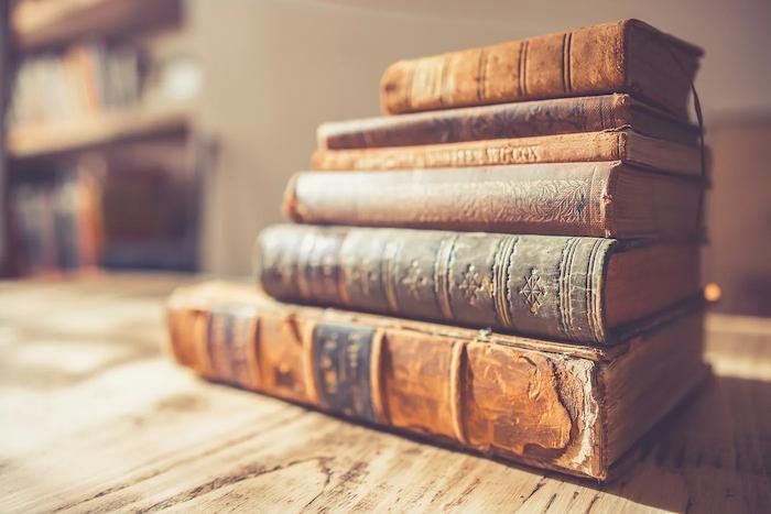 Stack of old books with worn spines 
