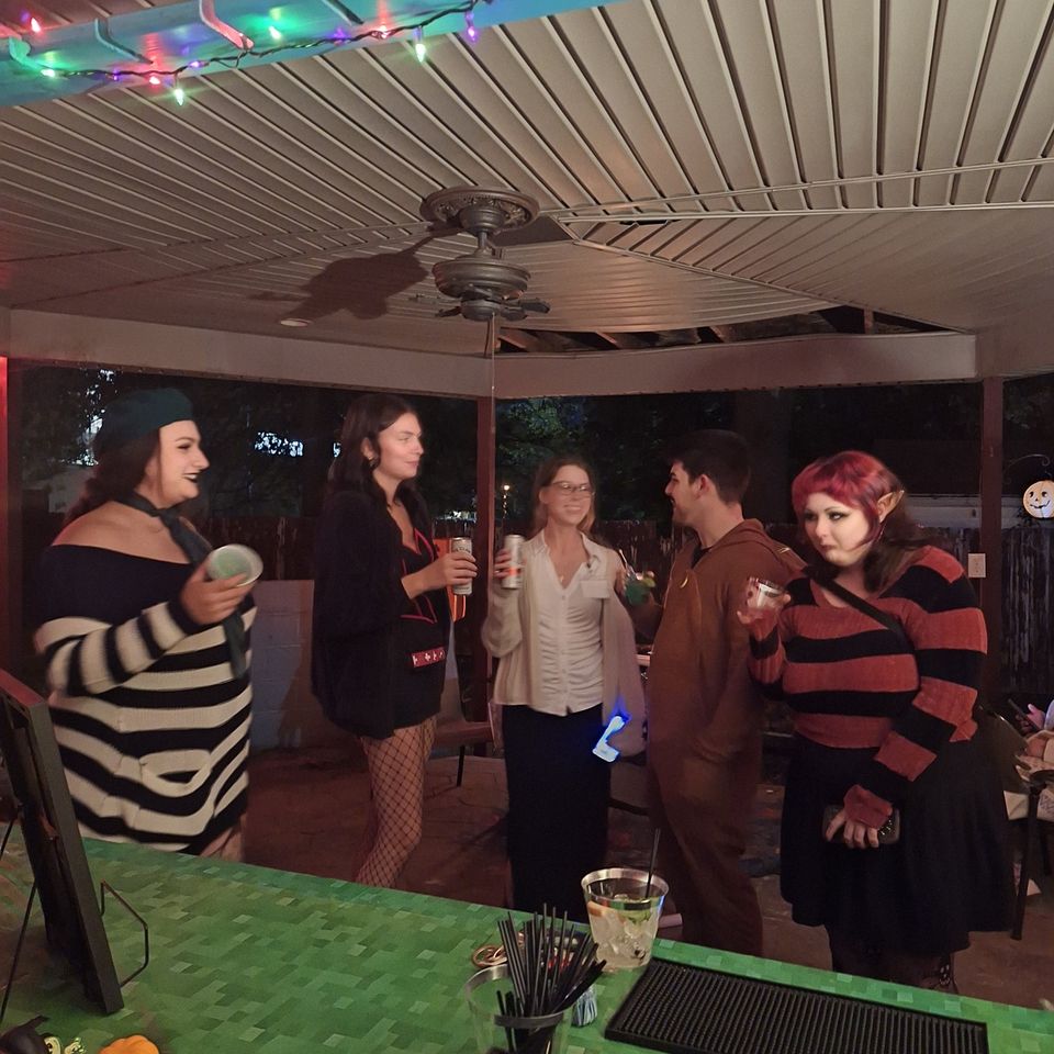Halloween party guests in costume enjoying drinks at the full bar