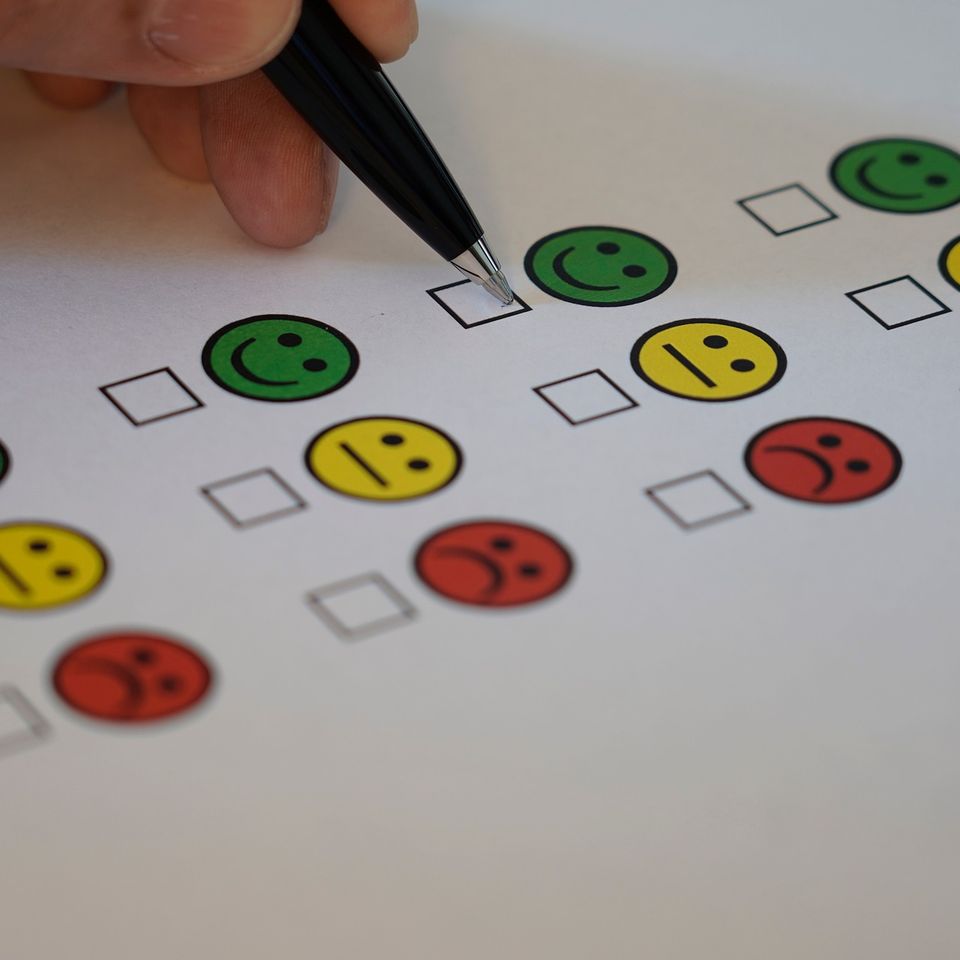 Survey form with a checkbox under a green smiley face, a yellow straight face, and a red frown face
