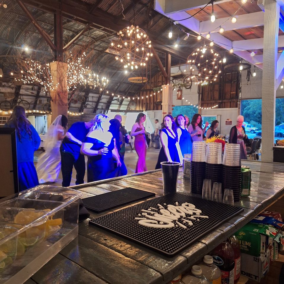 Guests on the dance floor with the full bar setup in the background