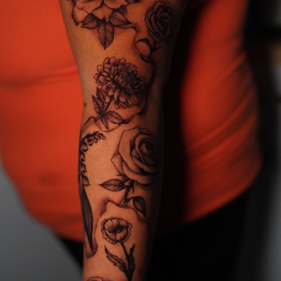 Image of a tattoo that covers from the shoulder to the wrist with space in between the individual tattoos.