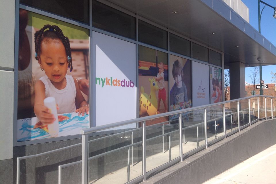 Printed vinyl window graphics with color photography and a logo covering a long glass storefront