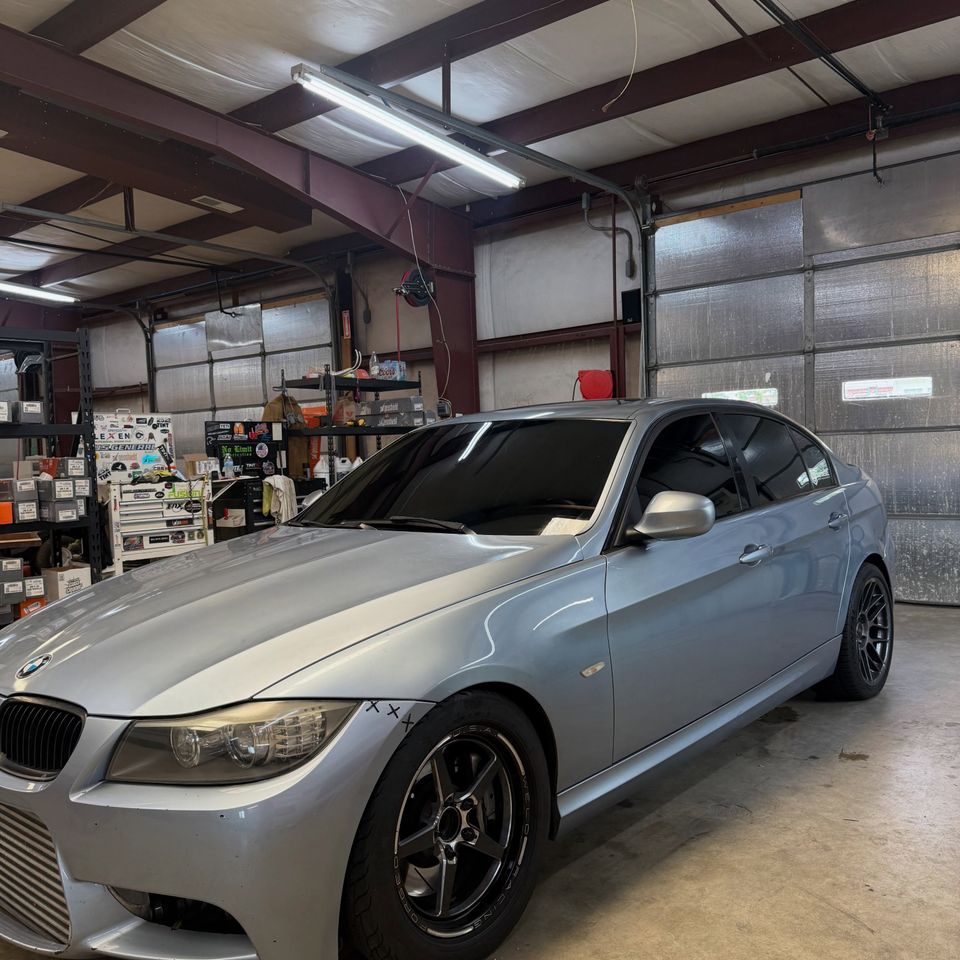 Silver BMW 3 Series with dark tinted windows inside the auto tint shop