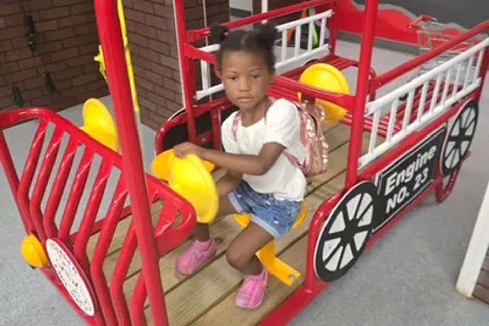 Child playing in a wooden car - firetruck with no engine