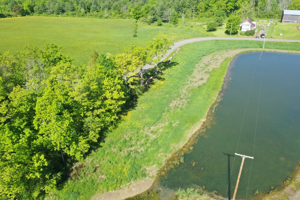 2025 arial drone looking west with pond and powerline