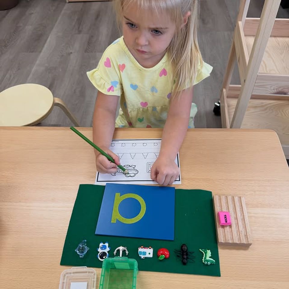 Preschool girl matching objects to the letter P during a Montessori phonics lesson in Palmdale CA