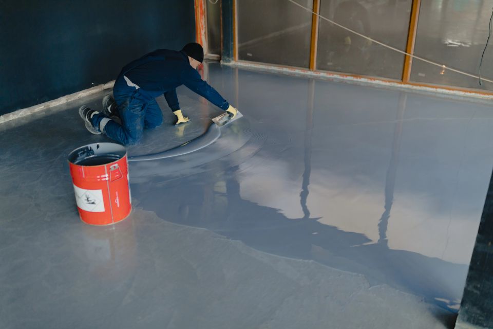 Vistacreate 441117760 stock photo worker applies gray epoxy resin new floor