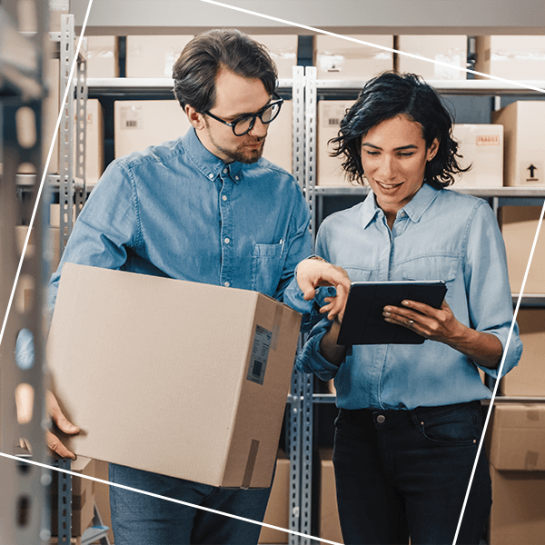 Man and women reviewing tablet in warehouse