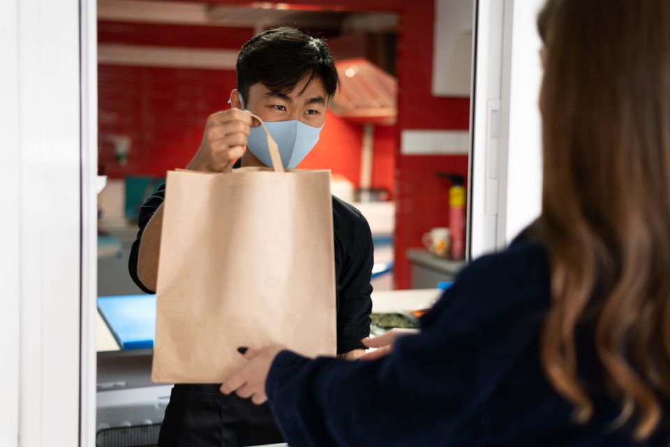 Restaurant worker handing order client