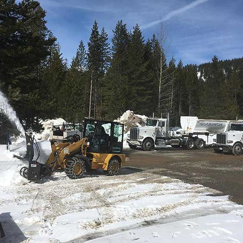 Mini loader blowing snow