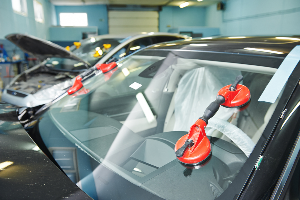 Newly installed vehicle windshield secured with professional installation tools during an auto glass replacement service.