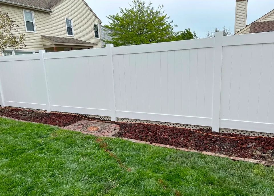 White vinyl privacy fence with lattice bottom installed along landscaped yard in Virginia Beach VA 