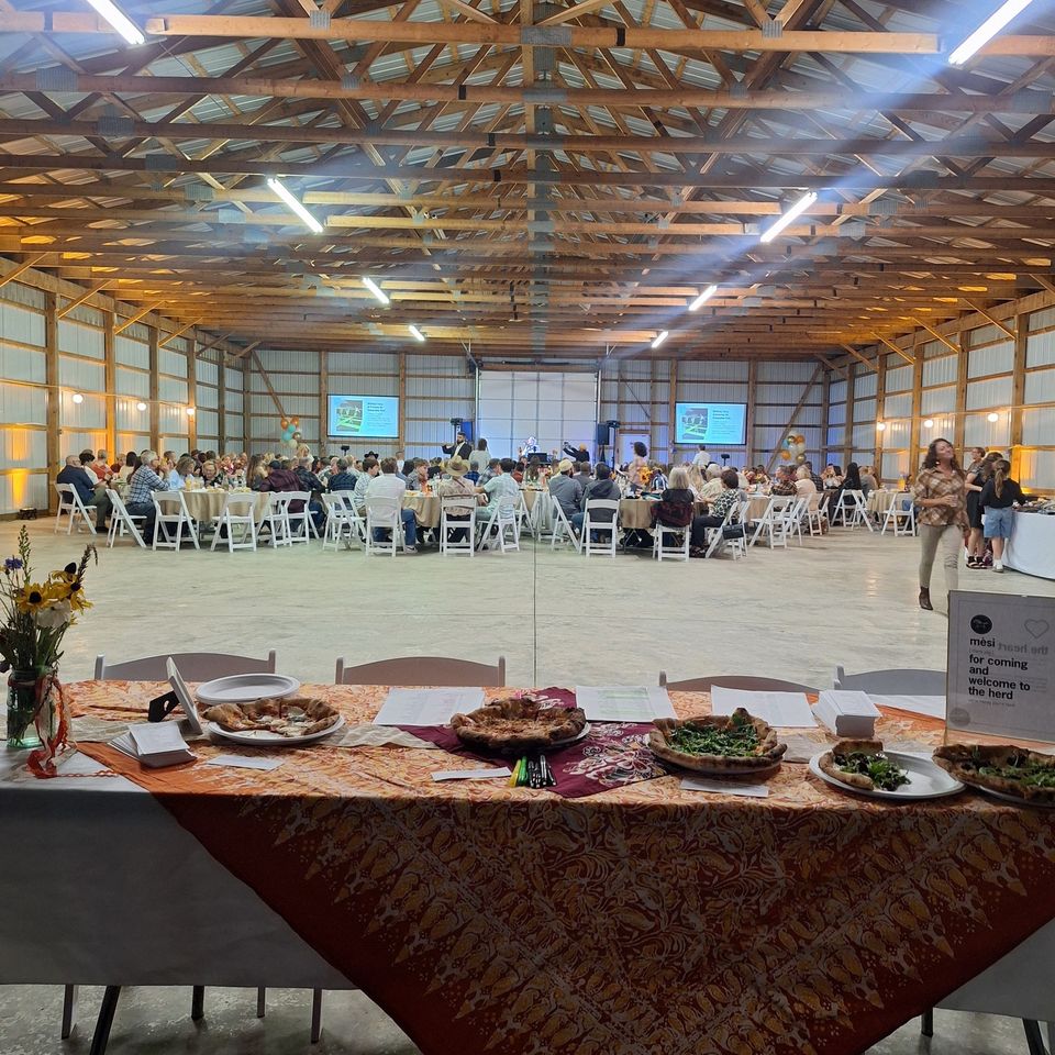 Large crowd seated at tables inside the venue