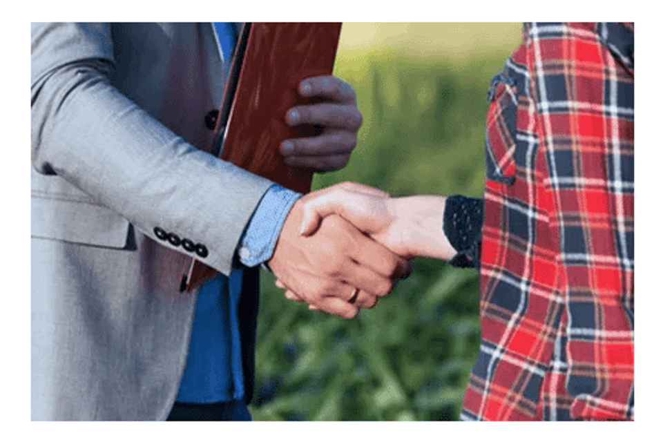 Insurance agent shaking hands with farmer