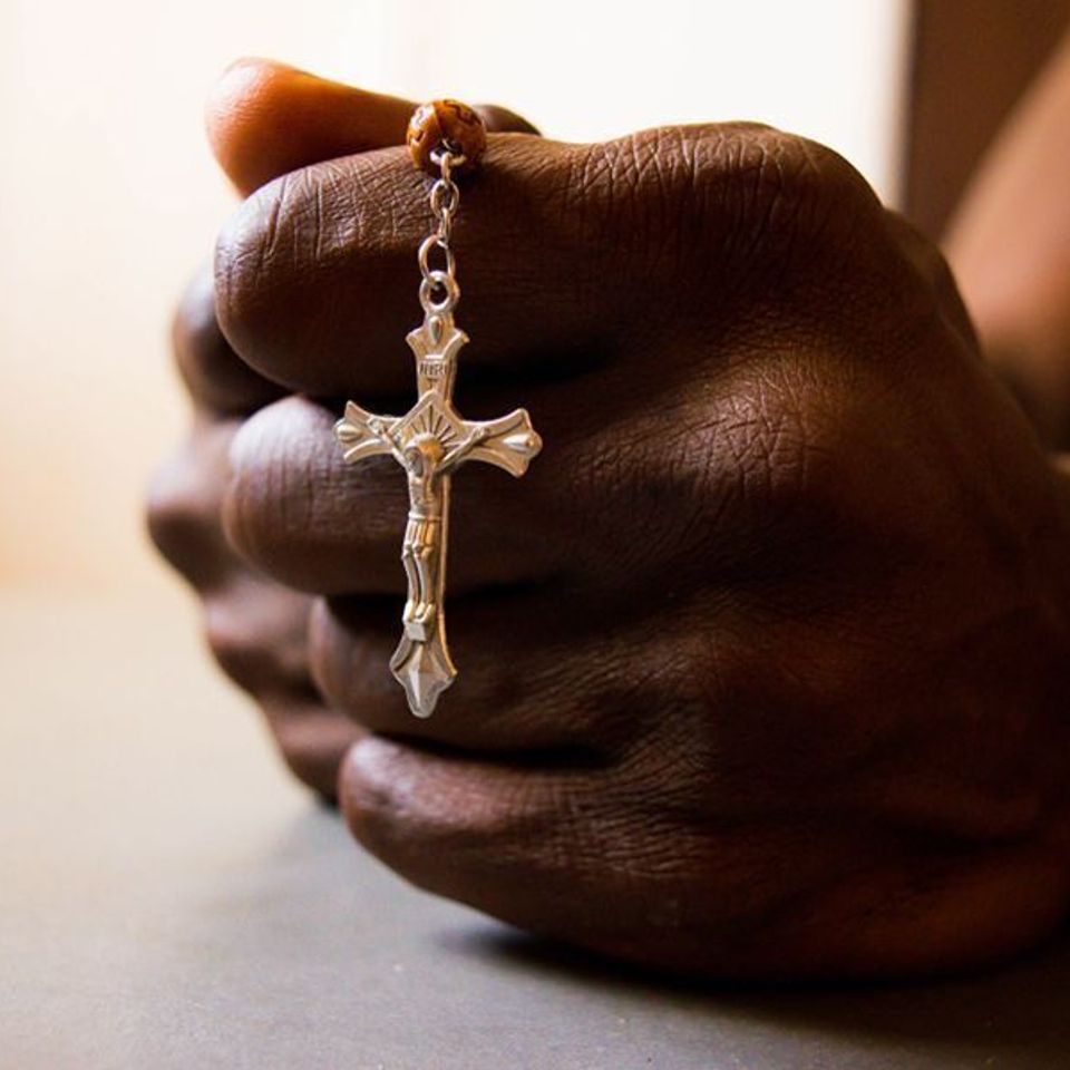 African man praying rosary credit red confidential shutterstock cna