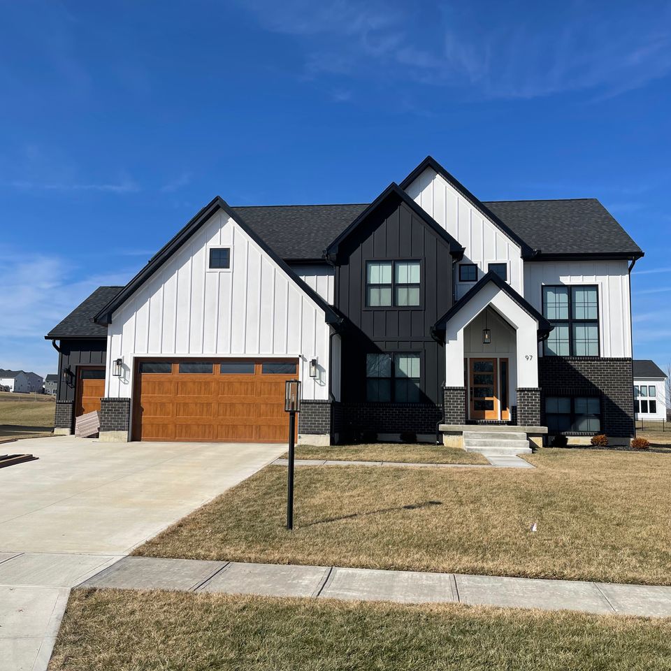 Two-story white and black home with a professionally installed dark gray architectural shingle roof by E & D Roofing, Inc.