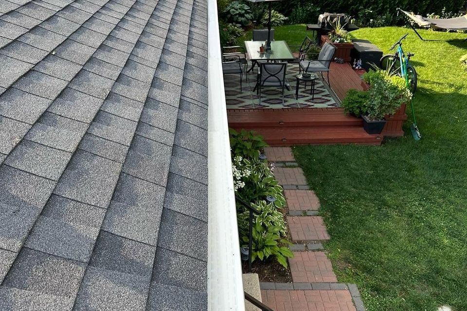 White gutter guard installed along asphalt shingle roof edge overlooking backyard patio in Tillsonburg ON