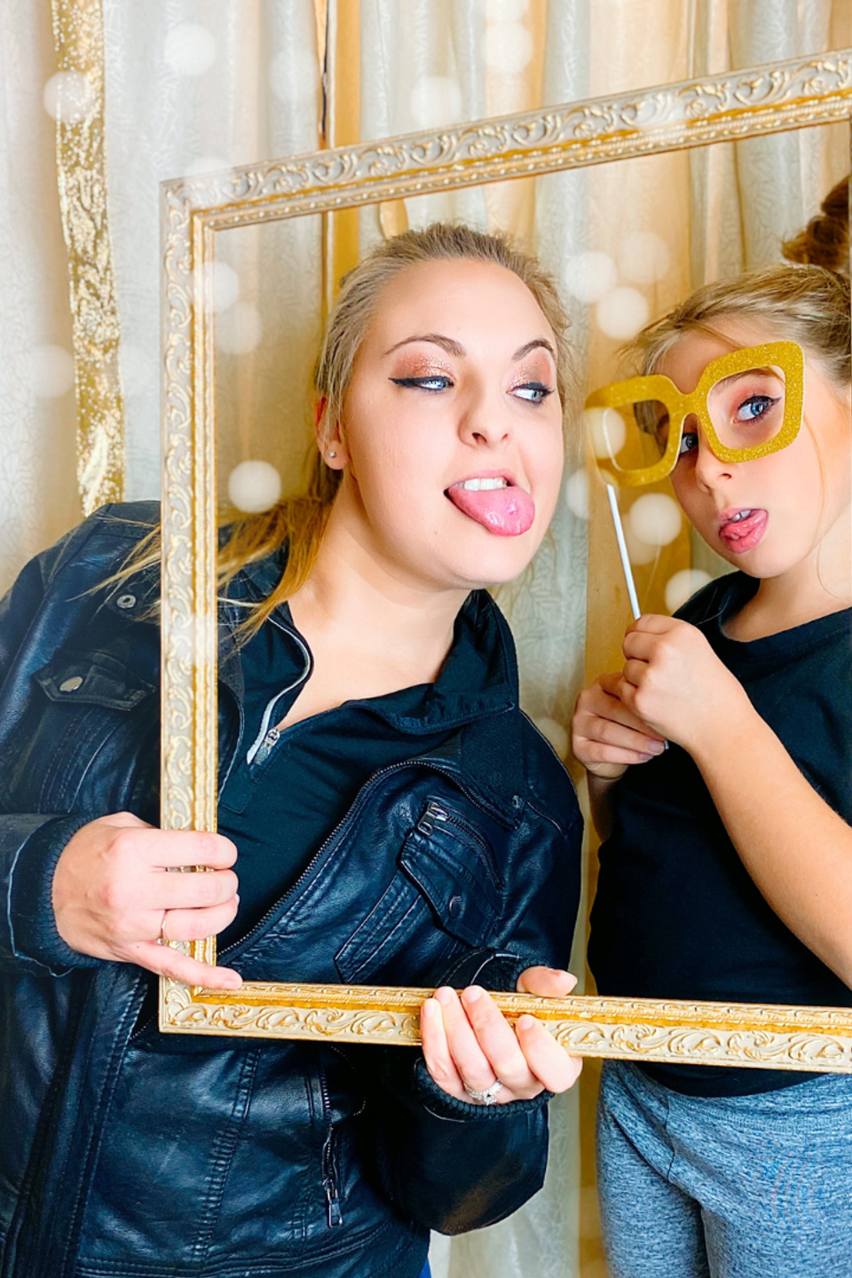 Two people using props and frame during a photo booth session.