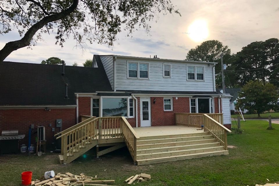 New pressure-treated wood deck with stairs and railings on brick home in Virginia Beach VA