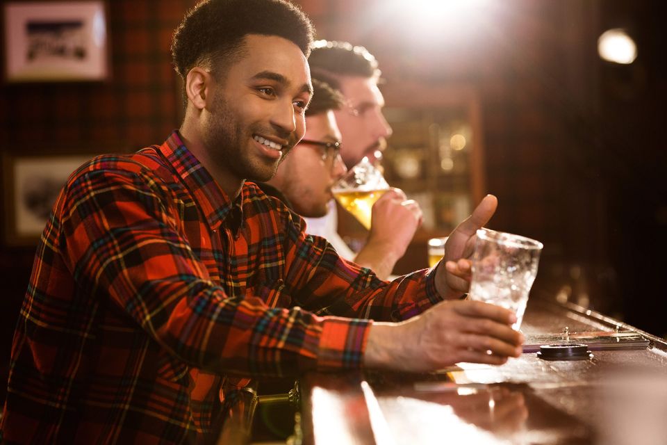 Happy friends drinking beer counter pub