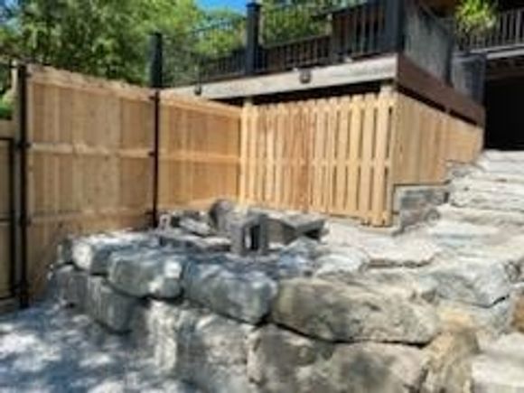 Challenging privacy fence install on rock landscape