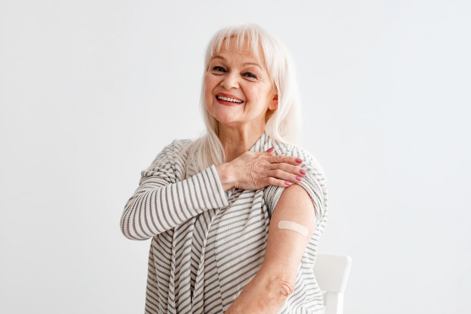 Portrait Of Happy Smiling Woman Showing Vaccinated Shoulder With Patch
