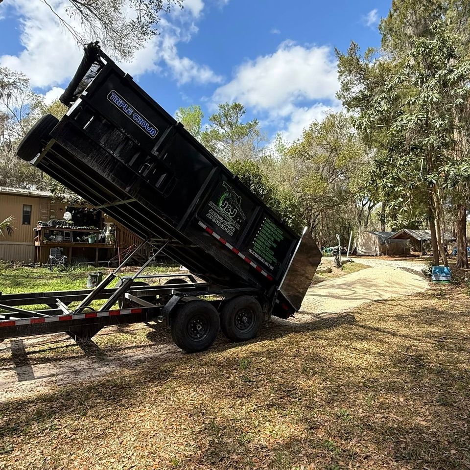 JNJ Hauling Solutions dumpster in the downward emptying position