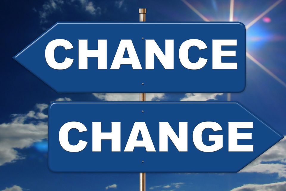 “Two blue directional signs reading ‘Chance’ and ‘Change’ against a sky background.”