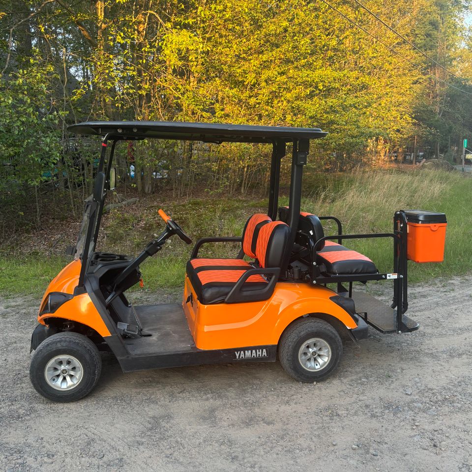 Side view of an orange golf cart rental from Mad Dog Golf Cart Rentals in Arrowhead Lake PA