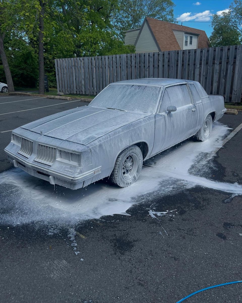 Oldsmobile Cutlass Supreme covered in thick snow foam during a mobile exterior wash in Wilmington DE