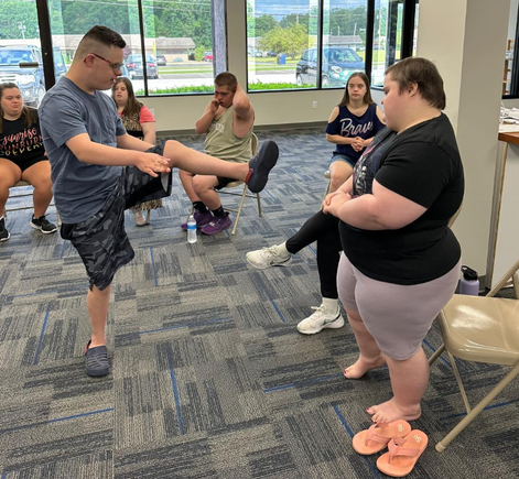 Participants practicing balance and coordination exercises during an adaptive fitness class at the Down Syndrome Association of the Valley.