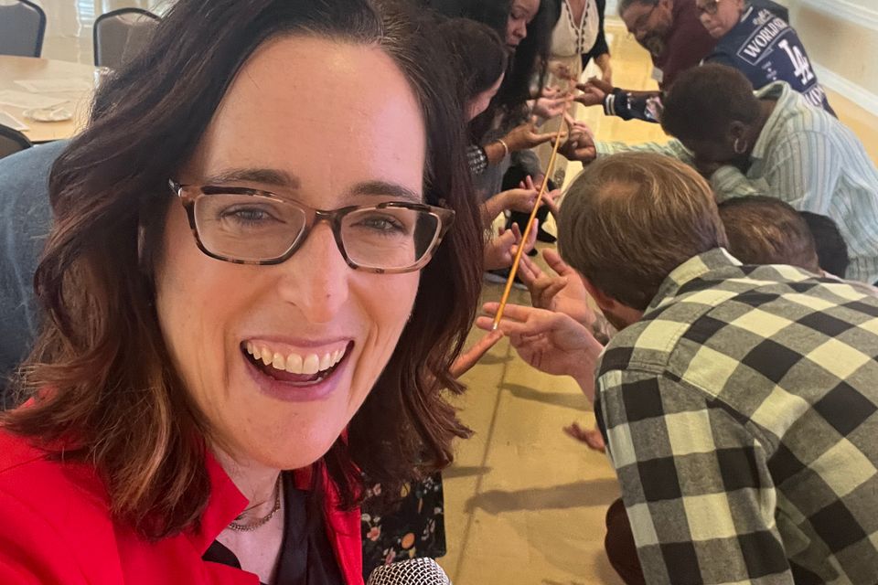woman with microphone speaking to a group