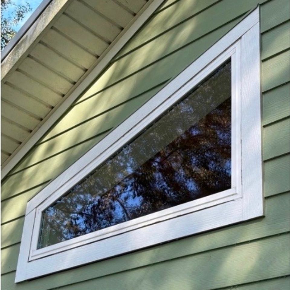 After photo of a clean window on a green house, done by 3D Exterior Solutions of Volusia County Florida