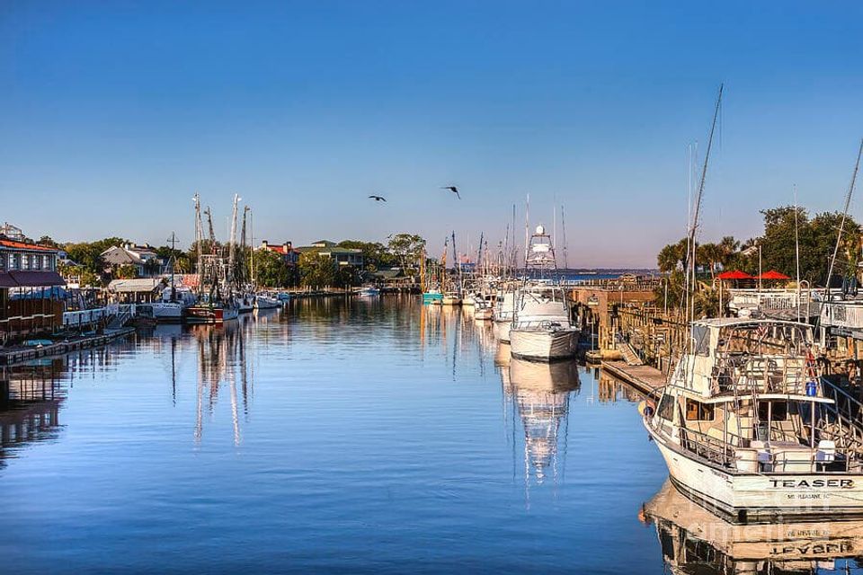 Boats docked along Shem Creek marina under soft early light