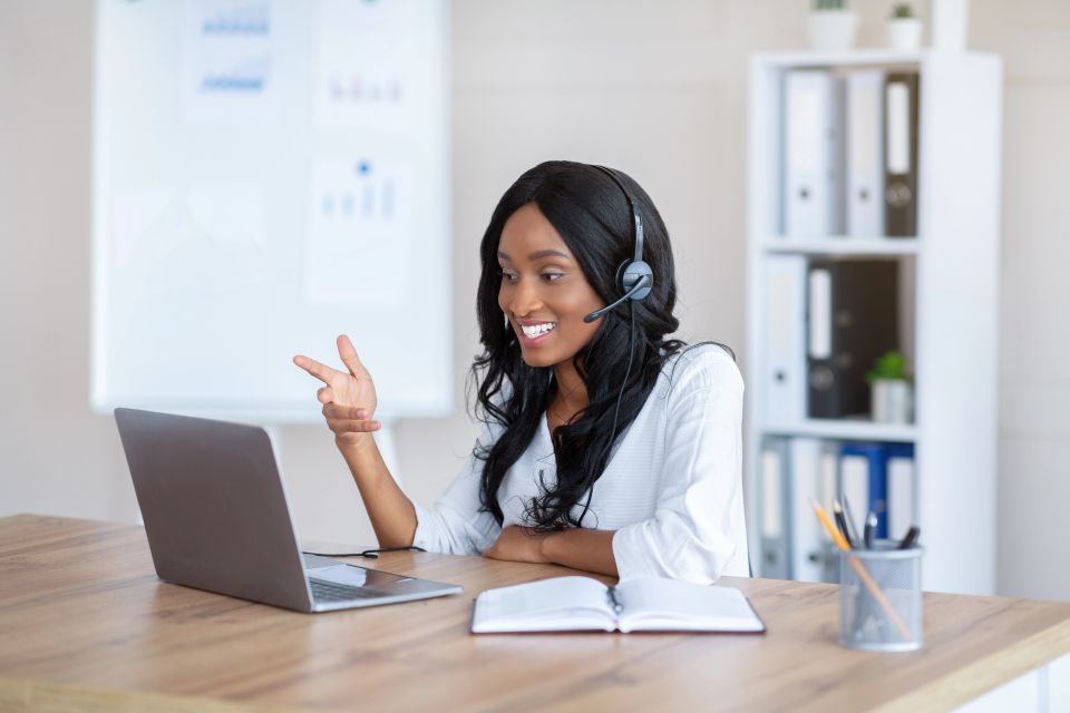 A female virtual assistant talking with someone on her laptop