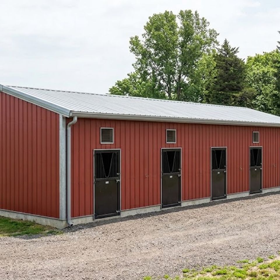 Red metal horse barn with five stall doors and gray roof on a Knoxville TN property