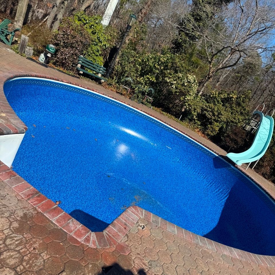 Kidney shaped inground pool with a new blue liner and brick coping installed in Long Island